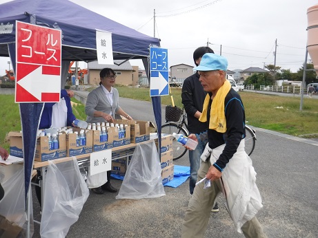 水分補給のテントがあり給水との張り紙のしてあるテーブルの上に水がたくさん置いてある写真