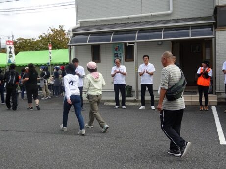 ゴール地点に辿り着いた人たちを拍手で迎える職員の写真